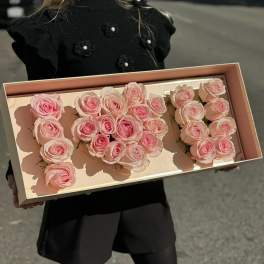 Box of pale pink roses arranged to form the number 100