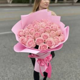 Bouquet of pink roses wrapped in pink paper with a ribbon