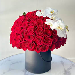 Red rose bouquet with white orchids in a black hat box