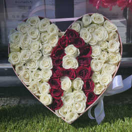 Heart-shaped box filled with white and red roses