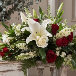 White lilies and red roses arranged in a low centerpiece
