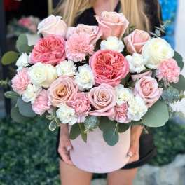 Pink and white roses with carnations in a round blush box