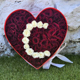Heart-shaped box filled with red and white roses