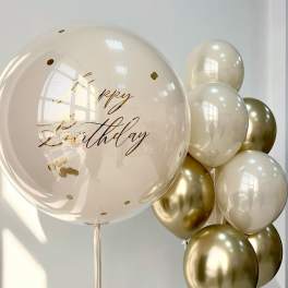 Birthday balloons in cream and gold with a large clear balloon