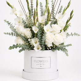 White roses and gladiolus in a white hatbox with eucalyptus