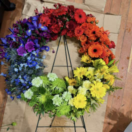 Rainbow floral wreath with red, orange, yellow, green, blue, and purple blooms