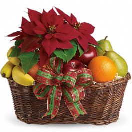 Wicker gift basket with red poinsettias, plaid ribbon, and assorted fresh fruit including bananas, apples, oranges, and pears.