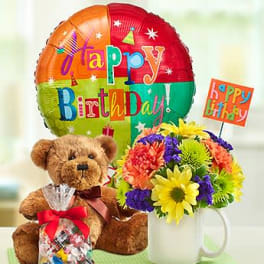 Birthday gift set with teddy bear, balloon, candies, and colorful mixed flowers in a white mug