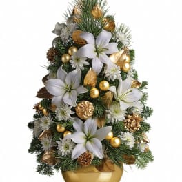 Christmas tree-shaped arrangement with white lilies and gold accents in a gold vase.