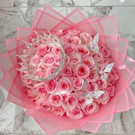 Bouquet of pink roses wrapped in pink paper with silver butterfly accents