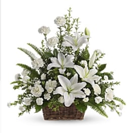 White lilies and carnations in a wicker basket