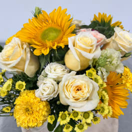 Bouquet of yellow sunflowers, cream roses, and yellow chrysanthemums