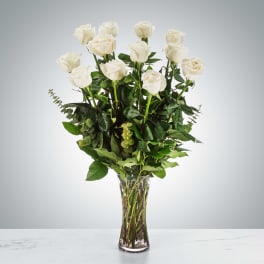 Arrangement of long-stem white roses in a tall clear glass vase