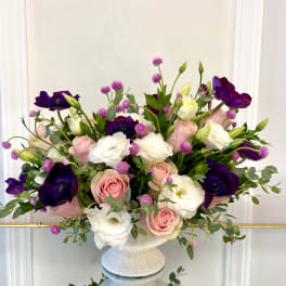Pink and white roses with purple anemones in a white vase
