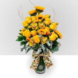 Yellow roses and sunflowers in a green glass vase with a sunflower ribbon