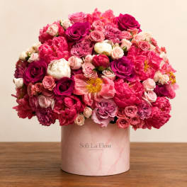 Pink and magenta rose bouquet in a blush cylindrical vase