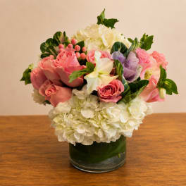 Pink roses and white hydrangeas arranged in a glass vase