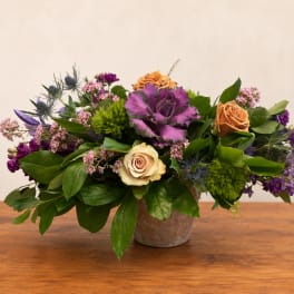 Mixed bouquet in a small pot with purple, peach, and cream flowers