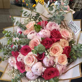 Hand-tied bouquet of pink and red roses with eucalyptus