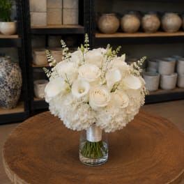 White roses and calla lilies in a glass vase