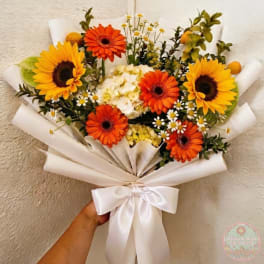 Bouquet of sunflowers and orange gerbera daisies wrapped in white paper