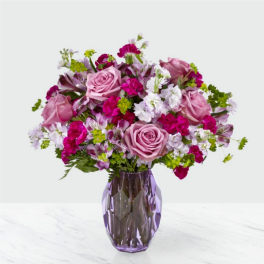 Pink and white mixed bouquet in a purple glass vase