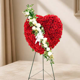 Heart-shaped red rose arrangement with a diagonal spray of white roses on a stand