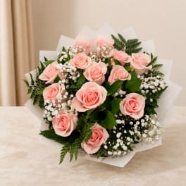 Bouquet of pale pink roses with white filler flowers and greenery