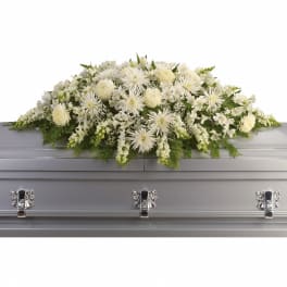 All-white casket spray of mixed flowers on a silver casket