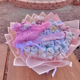 Pink baby gift bouquet with folded clothes and ribbons