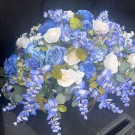 Blue and white rose bouquet with trailing blue flowers in a car trunk