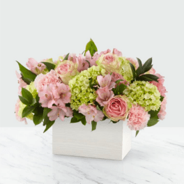 Pink and green floral arrangement in a white box