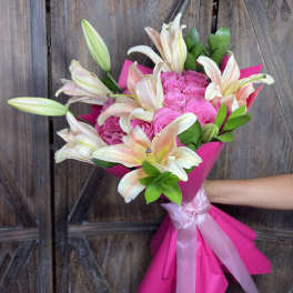 Pink rose bouquet with white lilies wrapped in bright pink paper