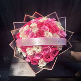 Heart-shaped bouquet of pink and white roses with a ribbon band