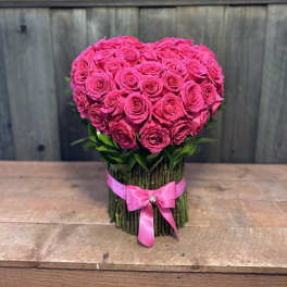 Heart-shaped bouquet of hot pink roses tied with a pink ribbon