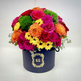 Bouquet of pink, orange, red, and yellow flowers in a navy hat box