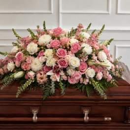 Pink and white floral spray arranged on a casket
