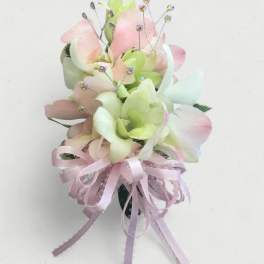 Small pastel floral corsage with pink and green petals and a ribbon bow