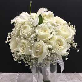 White rose bouquet with baby’s breath in a clear glass vase