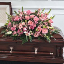 Pink rose casket spray with lilies and greenery
