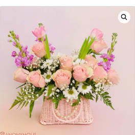 Pink roses and white daisies in a pink woven basket