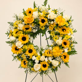 Yellow and white floral wreath on a stand