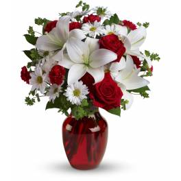 Red roses and white lilies in a red glass vase