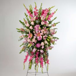 Tall pink floral standing spray on a metal easel