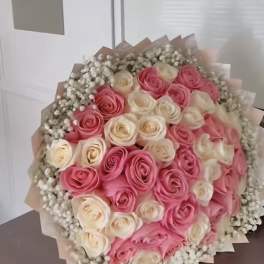 Bouquet of pink and cream roses wrapped in paper