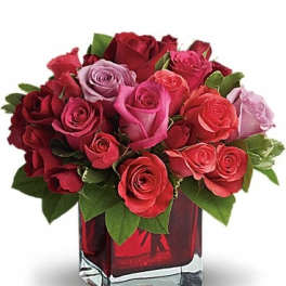 Bouquet of red and pink roses in a square glass vase