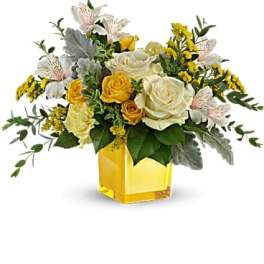 Yellow and white rose bouquet in a yellow glass vase