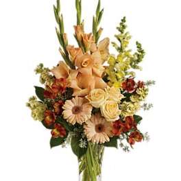 Peach and cream floral arrangement in a clear glass vase