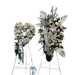 Two standing floral funeral sprays on metal easels with blue ribbons