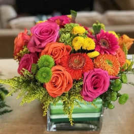 Bright mixed bouquet in a striped glass vase